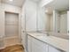 Modern bathroom featuring a vanity with a large mirror, tile surround shower and walk-in closet at 48275 Shetland Dr, Bennett, CO 80102