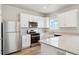 Well-lit kitchen featuring white cabinets, stainless steel appliances, and a spacious countertop area at 48275 Shetland Dr, Bennett, CO 80102