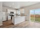 Modern kitchen featuring white cabinetry, stainless steel appliances, and an island, perfect for cooking and entertaining at 48275 Shetland Dr, Bennett, CO 80102