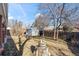 A serene backyard setting with a wooden fence, mature trees, and a small storage shed, creating a private outdoor space at 343 Melody Dr, Northglenn, CO 80260