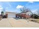 Single-Gathering home featuring brick accents, a spacious driveway, and an attached two-car garage at 343 Melody Dr, Northglenn, CO 80260