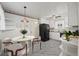 Kitchen showcasing a dining area, marble floors, a black refrigerator, and white cabinetry at 343 Melody Dr, Northglenn, CO 80260