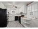 Cozy kitchen featuring marble floors, bright white cabinets, and black appliances at 343 Melody Dr, Northglenn, CO 80260