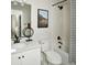Clean bathroom with a white vanity, combined tub and shower with patterned curtain, and minimalist decor at 6153 N Ceylon St # 305, Denver, CO 80249