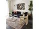 Inviting living room features a stylish sofa, modern coffee table, unique rug and a large window with decorative curtains at 6153 N Ceylon St # 305, Denver, CO 80249