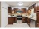 Updated kitchen features wood cabinets, stainless appliances, tile backsplash, and granite counters at 650 S Alton Way # 10A, Denver, CO 80247