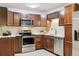 Updated kitchen features wood cabinets, stainless appliances, tile backsplash, and granite counters at 650 S Alton Way # 10A, Denver, CO 80247