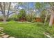 Expansive backyard featuring a well-maintained lawn and mature trees offering shade and privacy at 10165 W Iowa Ave, Lakewood, CO 80232