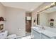 Bright bathroom with neutral tiling, a glass-enclosed shower, and a well-lit vanity at 10165 W Iowa Ave, Lakewood, CO 80232