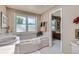 Relaxing bathroom with a soaking tub, large window and separate vanity area at 10165 W Iowa Ave, Lakewood, CO 80232