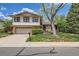 Charming home showcasing a well-manicured lawn, mature trees, and brick accents at 10165 W Iowa Ave, Lakewood, CO 80232