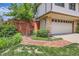 Home exterior with brick walkway and garage featuring lush greenery, enhancing curb appeal at 10165 W Iowa Ave, Lakewood, CO 80232