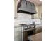 A gourmet kitchen boasts an ornate stainless steel range hood, custom cabinets and stone counter tops at 1275 Washington Ave, Golden, CO 80401