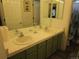 Bathroom with double sink vanity, tile countertop, a large mirror and two doors at 10522 Stoneflower Dr, Parker, CO 80134