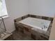 Large soaking tub with tile surround, and a window providing natural light, perfect for relaxation at 10522 Stoneflower Dr, Parker, CO 80134