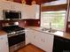 Functional kitchen features stainless steel appliances, white cabinets, and window views at 10522 Stoneflower Dr, Parker, CO 80134