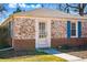 Charming brick home featuring a storm door entrance, blue shutters, and a well-maintained front lawn at 1257 Locust St, Denver, CO 80220