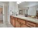 Granite countertop vanity features dual sinks, bronze faucets, framed mirror, and views the glass enclosed tile shower at 13475 Spruce St, Thornton, CO 80602