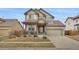 Charming two-story home featuring a well-manicured front yard, covered porch, and a two-car garage at 13475 Spruce St, Thornton, CO 80602