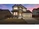 Two-story home featuring a well-maintained lawn, front porch, and a two-car garage with brick accents at 13475 Spruce St, Thornton, CO 80602