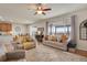 Open-concept living room with hardwood floors, comfortable seating, and a view into the backyard and patio at 13475 Spruce St, Thornton, CO 80602