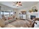Bright living room featuring a fireplace, hardwood floors, and a large window with backyard views at 13475 Spruce St, Thornton, CO 80602