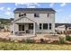 Back exterior view showcasing a covered patio, outdoor dining, and landscaped yard at 5446 Mesa Top Dr, Monument, CO 80132
