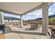 Spacious covered back patio with dining area, outdoor furniture, and mountain views at 5446 Mesa Top Dr, Monument, CO 80132