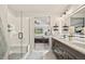 Bright bathroom offers a glass shower with bench, double sinks, and an open view into the primary bedroom at 5446 Mesa Top Dr, Monument, CO 80132