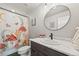 Charming bathroom showcasing a mushroom-themed shower curtain, a modern vanity, and a round mirror at 5446 Mesa Top Dr, Monument, CO 80132