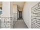 Inviting covered entryway featuring a modern door, stone accents, and neutral tones at 5446 Mesa Top Dr, Monument, CO 80132