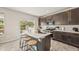 Modern kitchen featuring a large island with seating, stainless steel appliances, and stylish dark cabinets at 5446 Mesa Top Dr, Monument, CO 80132