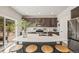 Modern kitchen featuring a large island with seating, stainless steel appliances, and stylish dark cabinets at 5446 Mesa Top Dr, Monument, CO 80132