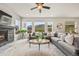 Bright living room with a stone fireplace, large windows with mountain views, and a comfortable gray sofa at 5446 Mesa Top Dr, Monument, CO 80132