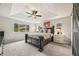 Bright main bedroom featuring scenic views, a ceiling fan, plush carpet, tray ceiling, and a dark wood bedframe at 5446 Mesa Top Dr, Monument, CO 80132