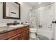 Cozy bathroom featuring a vanity with a framed mirror and a shower-tub combination with a patterned curtain at 6852 S Algonquian Ct, Aurora, CO 80016