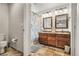 Charming bathroom featuring a double vanity with framed mirrors and a shower with a patterned curtain at 6852 S Algonquian Ct, Aurora, CO 80016