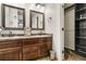 A bathroom with a double vanity, framed mirrors, and an open closet offer both style and functionality at 6852 S Algonquian Ct, Aurora, CO 80016