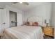 A bright bedroom featuring a striped bedspread, decorative pillows, and closet with shelving in a neutral color palette at 6852 S Algonquian Ct, Aurora, CO 80016