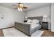 A stylish bedroom features a tufted gray bed frame with a ceiling fan and two bedside tables with lamps at 6852 S Algonquian Ct, Aurora, CO 80016