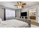 This bedroom boasts a TV, bright window, and an en-suite bathroom for added convenience and comfort at 6852 S Algonquian Ct, Aurora, CO 80016