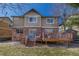 Back exterior featuring a brick and vinyl house with dual-level decks and a yard at 6852 S Algonquian Ct, Aurora, CO 80016