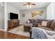 Cozy living room with a plush sectional, a patterned rug, and a stylish entertainment center at 6852 S Algonquian Ct, Aurora, CO 80016