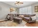 Comfortable living room featuring an oversized sectional sofa, an ottoman, and soft floral rug at 6852 S Algonquian Ct, Aurora, CO 80016