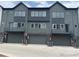 Contemporary townhome featuring garage doors and modern gray-tone exterior at 694 Saddle Dr, Erie, CO 80516