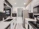 Modern kitchen with stainless steel appliances, black hardware, white cabinets, and elegant herringbone backsplash at 4068 S Atchison Way # 101, Aurora, CO 80014
