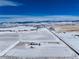 Aerial view of a rural home surrounded by snow-covered plains and mountains at 10650 Yellowstone Rd, Longmont, CO 80504
