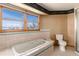 Bathroom featuring a tiled bathtub under a window with outside views at 10650 Yellowstone Rd, Longmont, CO 80504