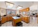 Spacious kitchen with oak cabinets, kitchen island, and views of the snow-covered landscape at 10650 Yellowstone Rd, Longmont, CO 80504