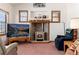 Cozy living room with a brick fireplace, wood mantel, and lots of natural light at 10650 Yellowstone Rd, Longmont, CO 80504